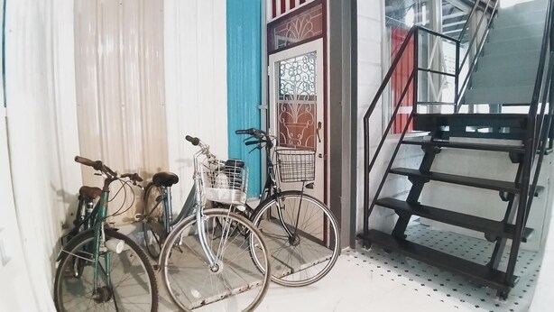 A staircase with a metal railing, a door with decorative glass panels, and two bicycles parked outside.