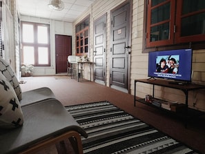En stue med en sofa, et fjernsyn og en gulvtæppe med et mønster.