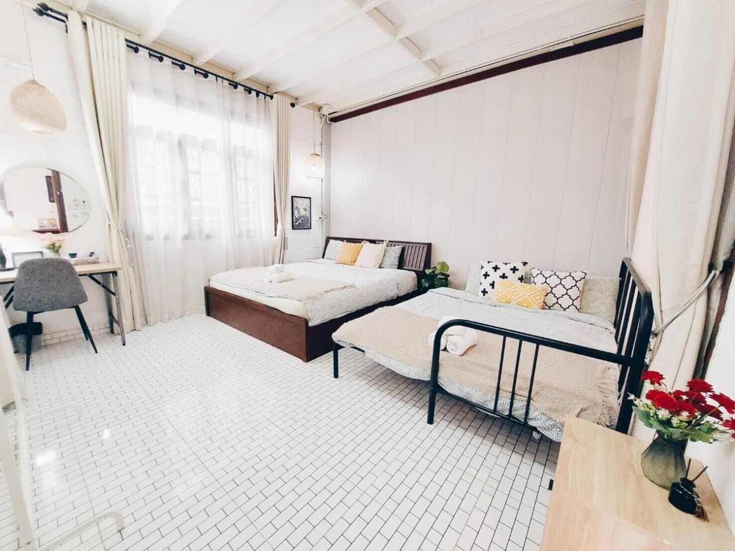 Quarto com cama, mesas de cabeceira, escrivaninha e uma cadeira.