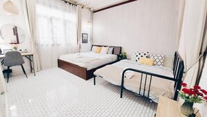 A bedroom with a bed, bedside tables, a desk, and a chair.