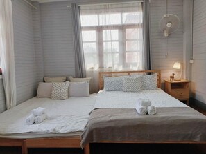 A bedroom with a wooden bed, two bedside tables, a nightstand with a lamp, and a window with curtains. - The Warehouse - Ayutthaya (Ayutthaya)