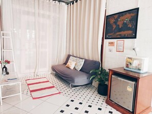 A living room with a sofa, a small table, a refrigerator, a plant, and a ladder. - The Warehouse - Ayutthaya (Ayutthaya)
