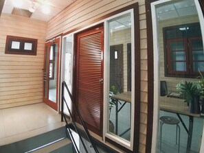 A modern interior with a staircase, wooden panel walls, and a dining area with a table and chairs. - The Warehouse - Ayutthaya (Ayutthaya)