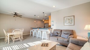 A living room with a brown sofa, a coffee table, and a dining area with a wooden table and chairs. - 2 Blocks to Beach: Cozy Retreat in Wildwood! (Wildwood)