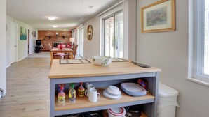 Una cocina amplia con encimera de madera, un fregadero y un comedor al fondo.