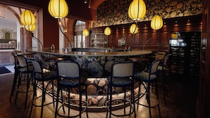 A bar area with a central island, bar stools, and hanging lamps. -  Henrik's Hotel (Copenhagen)