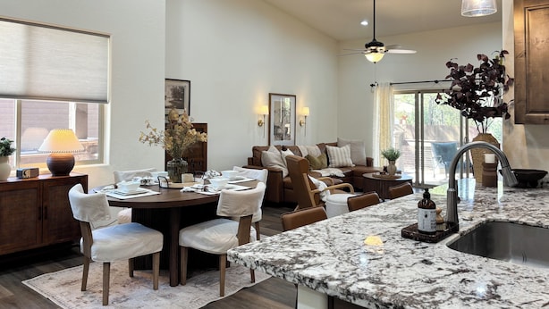 A modern kitchen with a granite countertop, a dining area with a round table and chairs, and a cozy seating area with a sofa and armchairs. - < 3 Mi to Fool Hollow Lake: Show Low Townhome (Show Low)