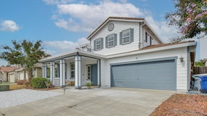 A two-story house with a garage, a covered porch, and a driveway.