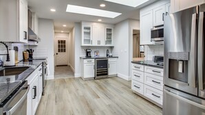 A modern kitchen with white cabinetry, stainless steel appliances, and a skylight. - 2 1/2 Mi to Bethany Boardwalk! Private Retreat! (Ocean View)
