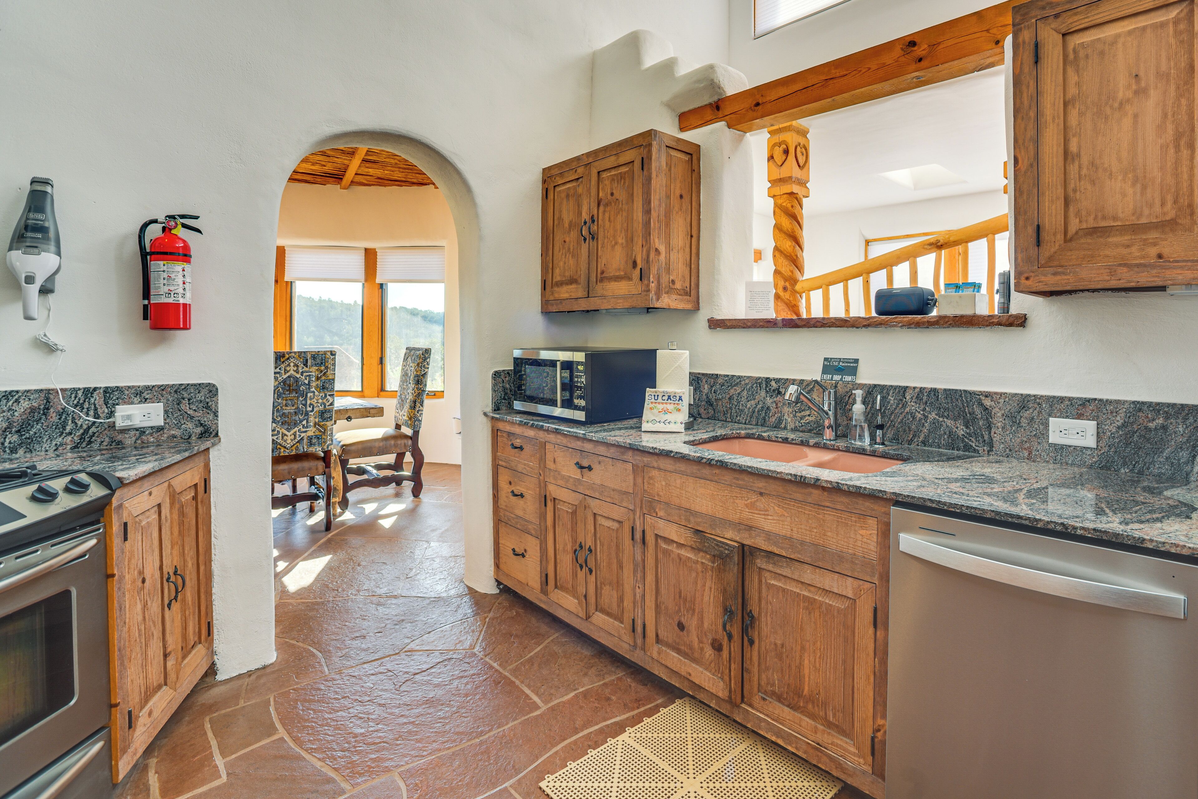 A kitchen with wooden cabinets, granite countertops, a microwave, and a dishwasher.