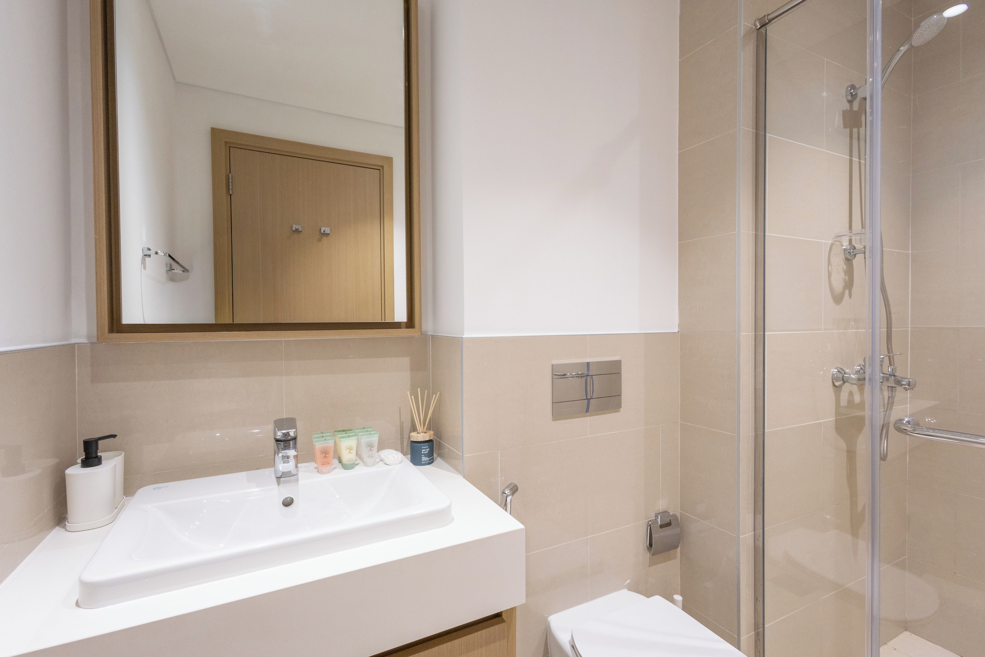 Ein Badezimmer mit Waschbecken, Spiegel, Dusche und Holzschrank.
