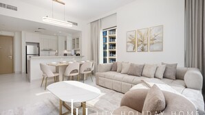 Una sala de estar moderna con un sofá, una mesa de comedor con sillas y una cocina al fondo.
