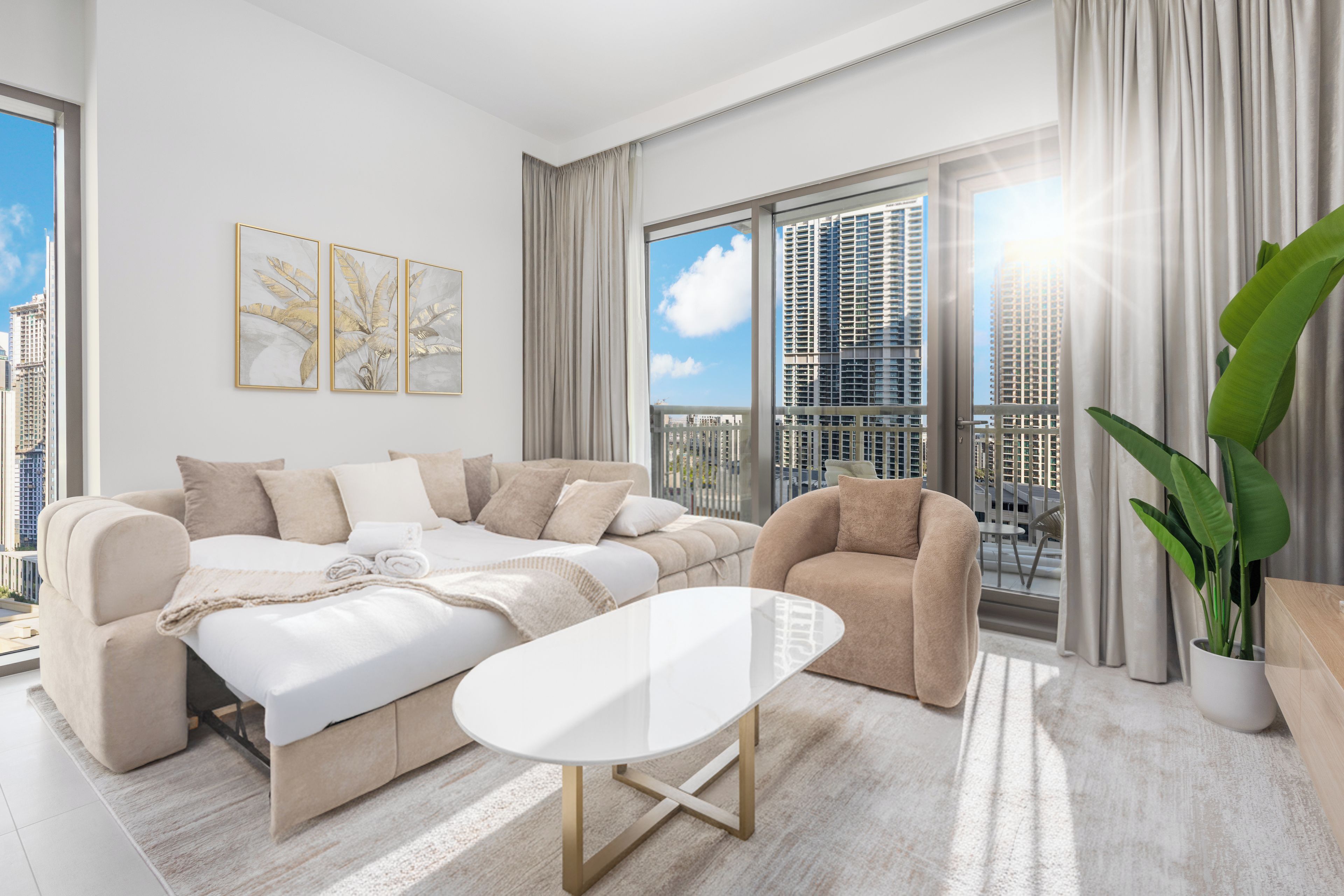 A modern living room with a sofa set, a coffee table, and a view of a cityscape through large windows.