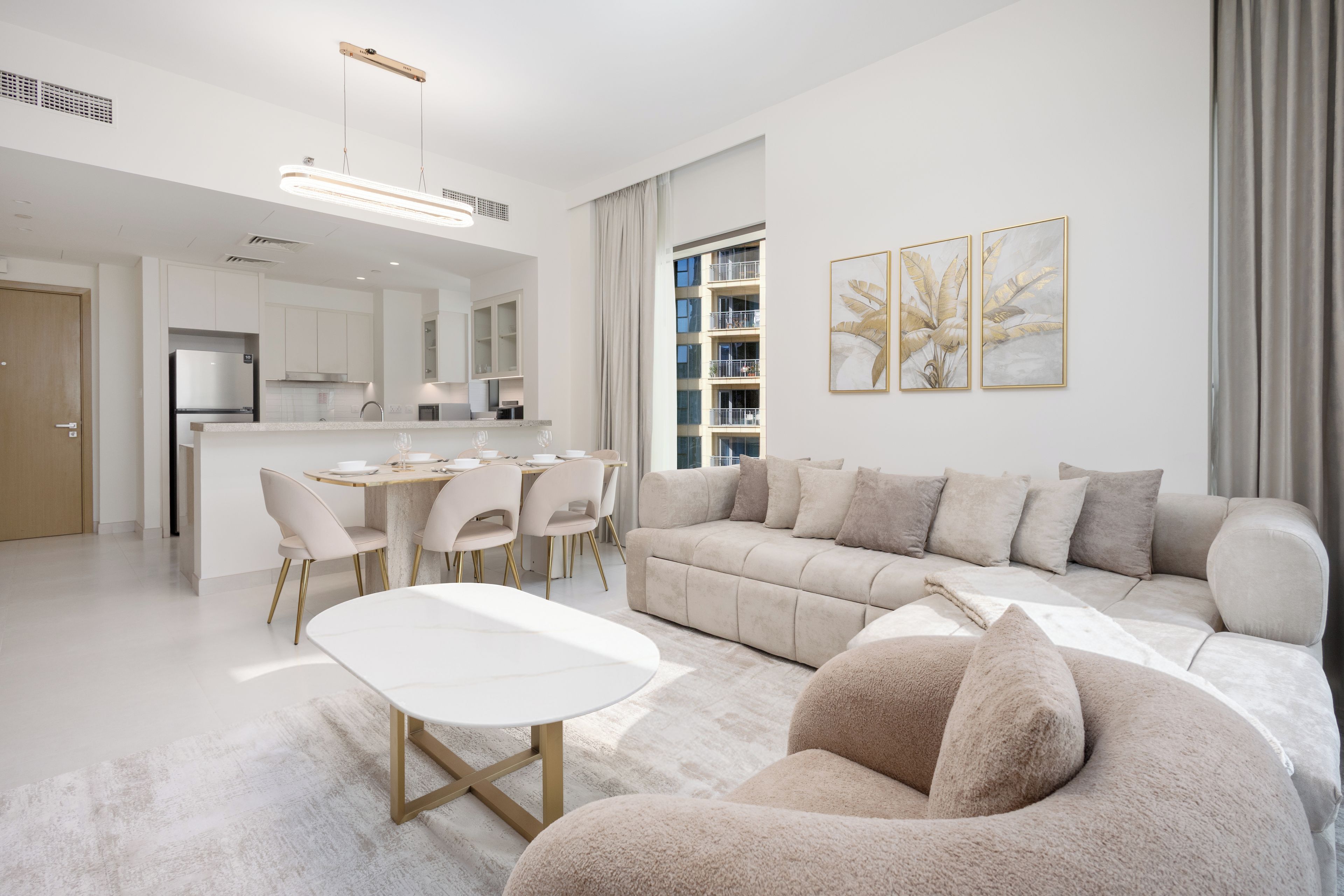 A modern living room with a sofa, a coffee table, and a dining area with chairs.