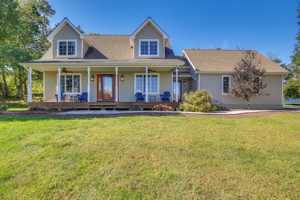 A two-story house with a front porch, a covered entryway, and a small deck area.