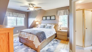 A bedroom with a wooden bed, a nightstand, a ceiling fan, and a window with a valance. - New Milford Home: 29 Mi to Lime Rock Park! (New Milford)