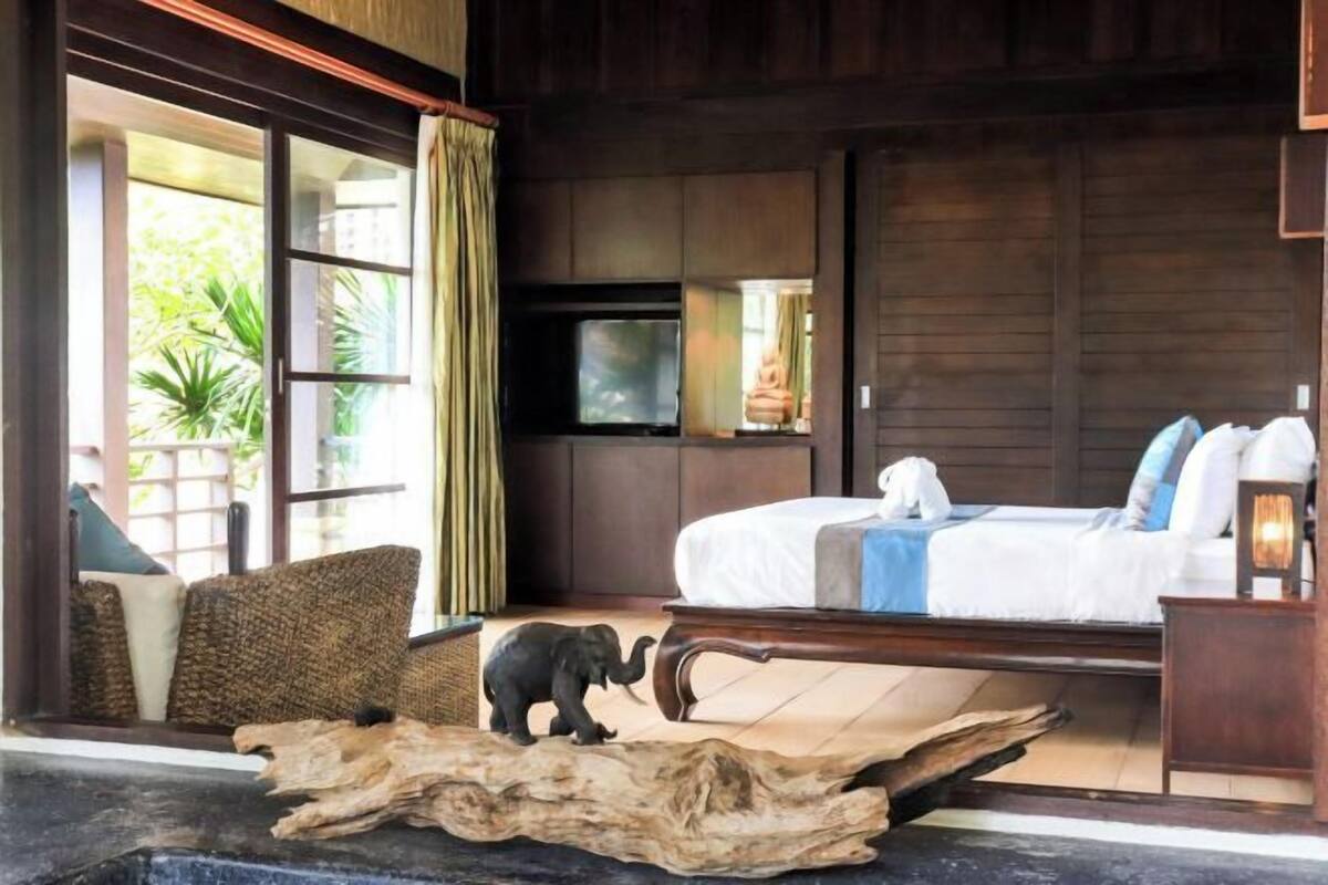 A bedroom with a bed, a television, and a small elephant figurine.