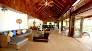 A spacious living area with a high ceiling, a sofa set, a coffee table, and a statue. - Ban Kinaree (Koh Samui)