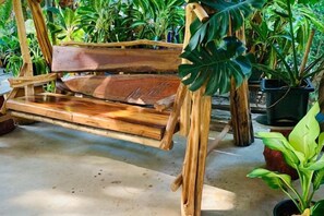 A wooden swing chair in a garden area with potted plants around. - Suan Lung Rin Resort Cha Am (Cha-am)