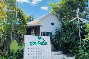 A white building with a signboard in front, surrounded by greenery and a clear sky. - Suan Lung Rin Resort Cha Am (Cha-am)