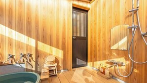 Une salle de sauna en bois, avec un banc en bois, une petite table en bois, une grande baignoire et un espace douche.