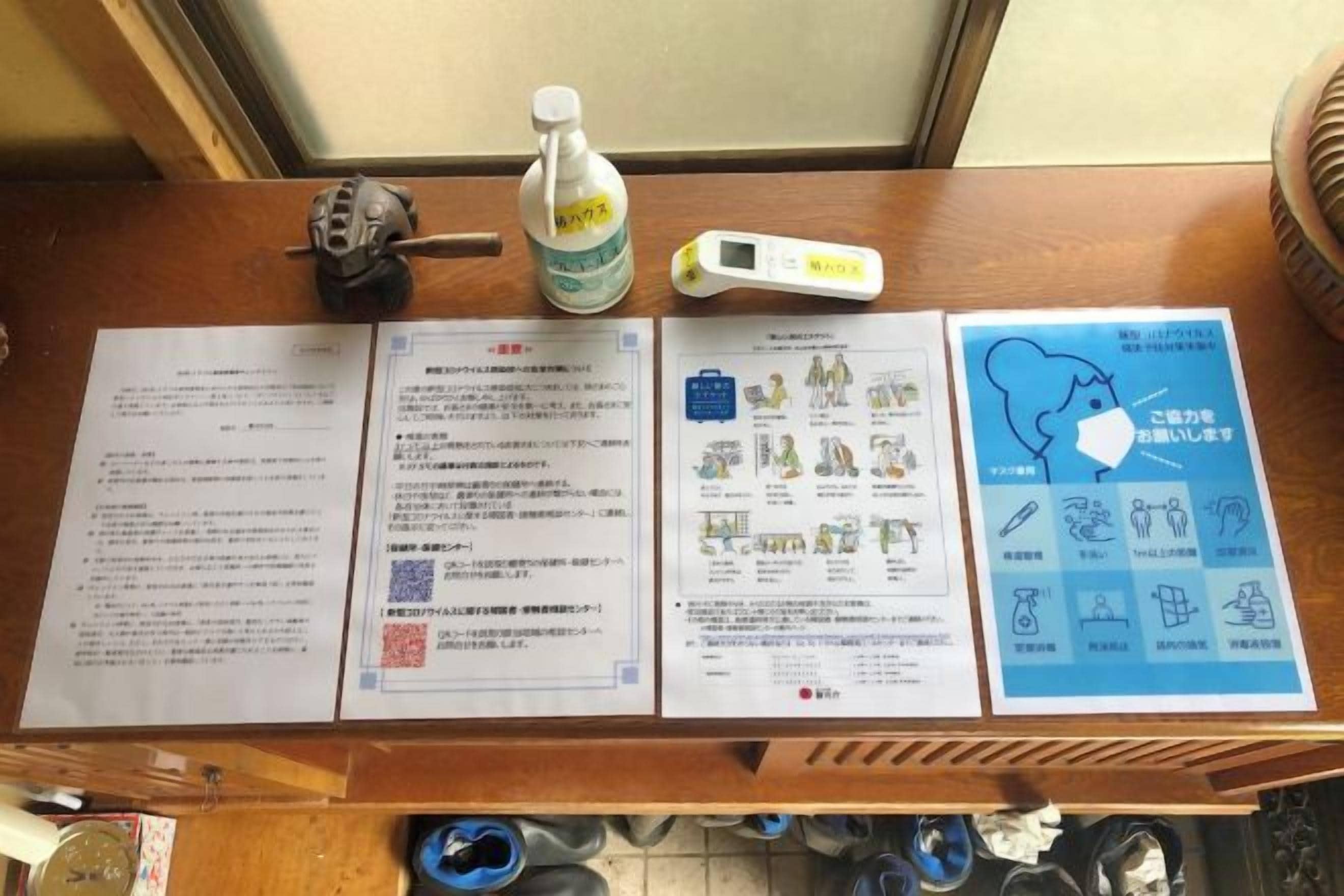 Una mesa de madera con documentos, una botella de agua y un termómetro.