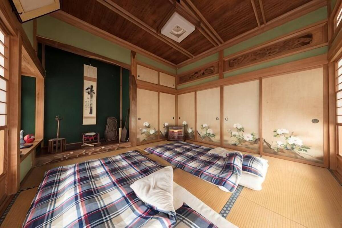 Une pièce de style japonais traditionnel, avec un sol recouvert de tatamis, des paravents en papier de riz (shoji) et un futon servant de lit.