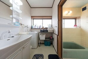 Un bagno compatto con lavandino, specchio e vasca da bagno.