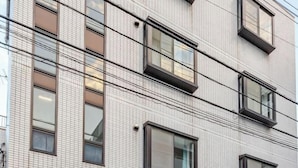 A multi-story building with a tiled facade and multiple windows. - Aladdin House (Tokyo)