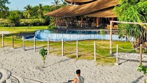 A beachside resort with a pool, a covered seating area, and a sandy walkway. - Tanoma Sumba Beach Resort (Kadumbul)