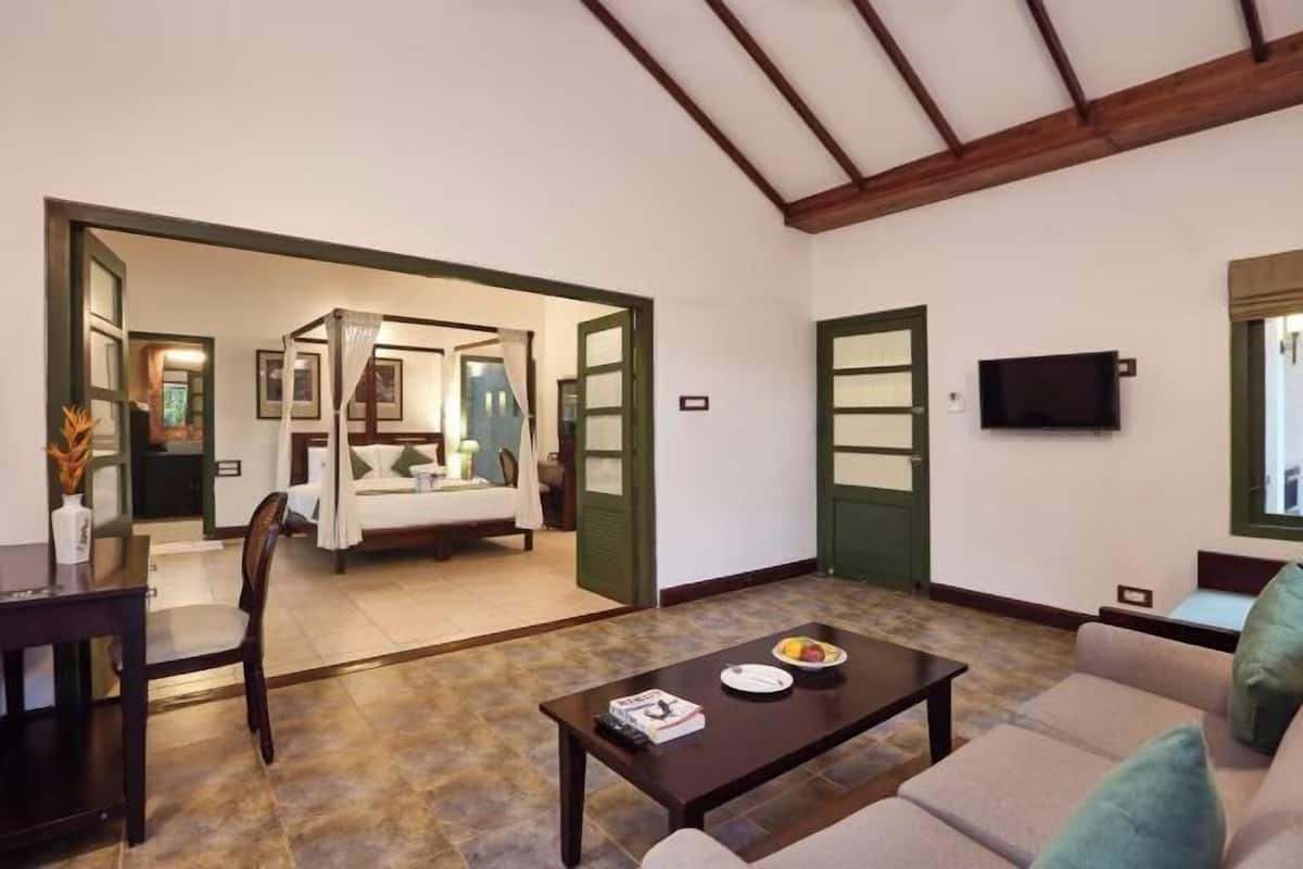 Une chambre d’hôtel comprenant un coin repas, un canapé, une table basse et un téléviseur.