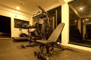 A gym with exercise equipment, a bench, and a treadmill. - Reen Resorts Aanavilasam Plantation Thekkady (Thekkady)