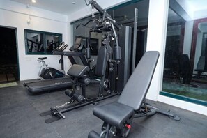 A gym with exercise equipment, a treadmill, and a bench. - Reen Resorts Aanavilasam Plantation Thekkady (Thekkady)
