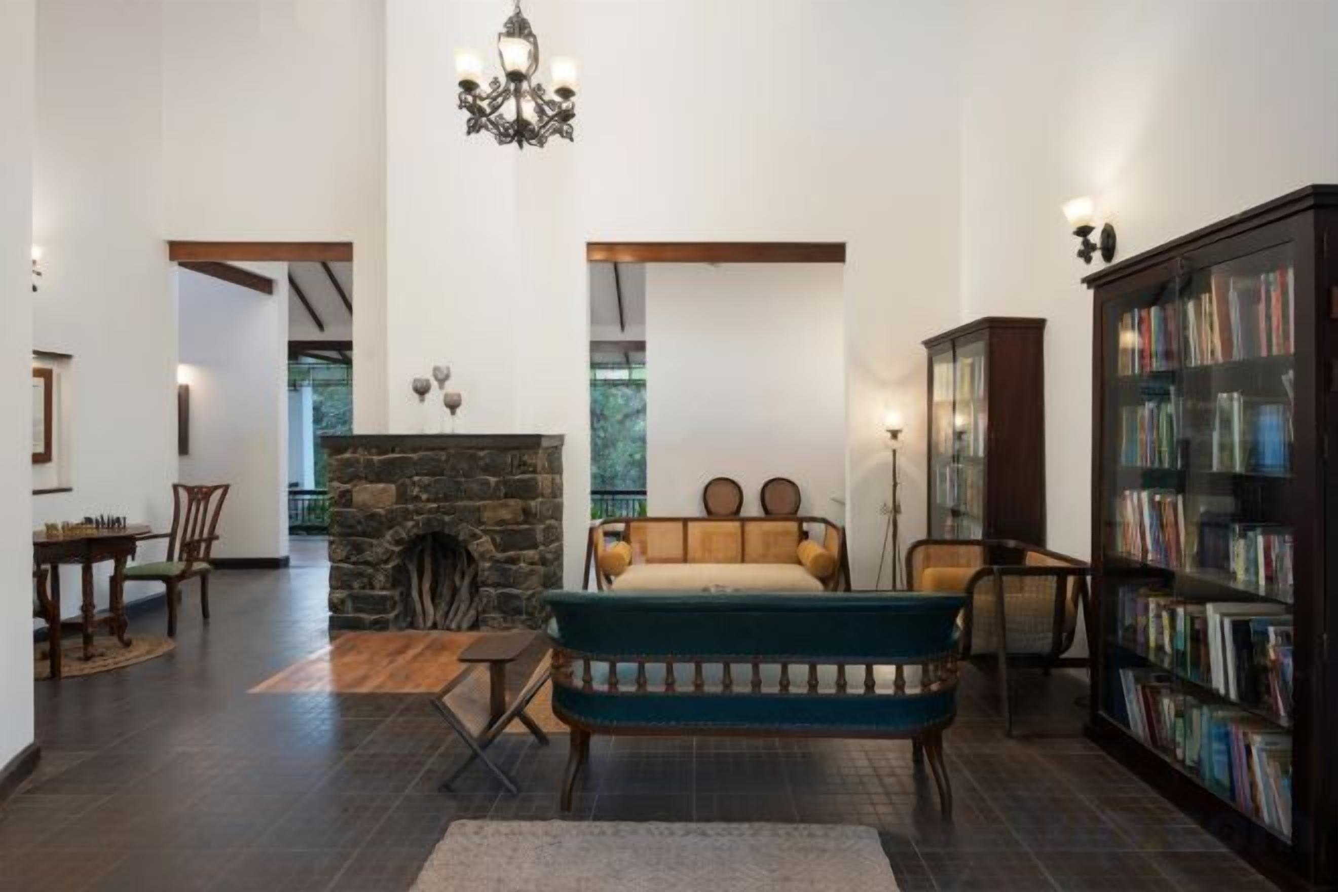 A spacious living room with a stone fireplace, a large bookshelf, and a comfortable seating area.