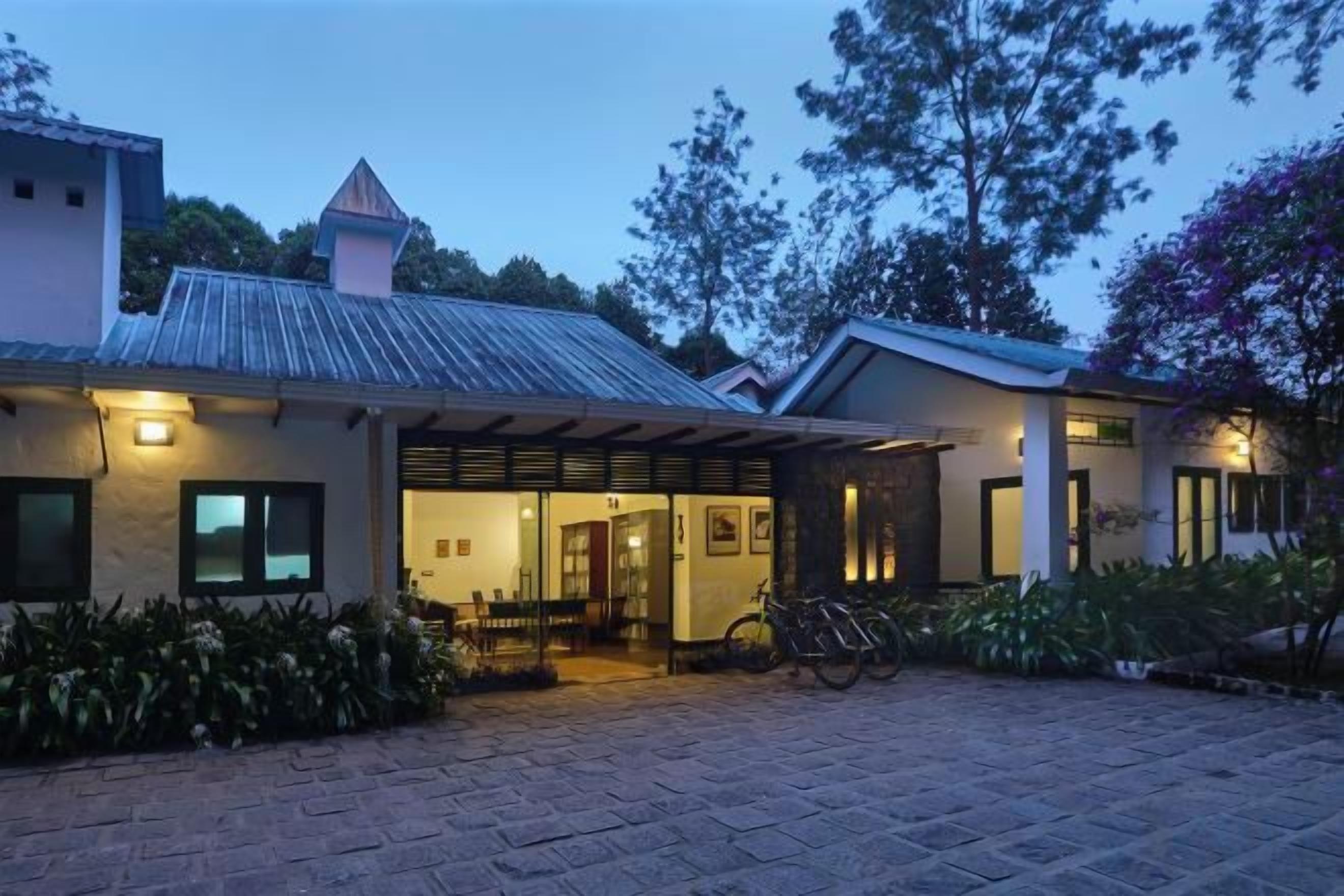A two-story building with a covered entrance, a bicycle parked outside, and a paved driveway.