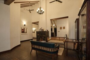 Amplia sala de estar con un banco, una chimenea y un ventilador de techo.