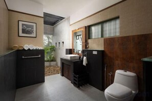 Un baño moderno con un tocador negro, un inodoro blanco y un espejo grande.