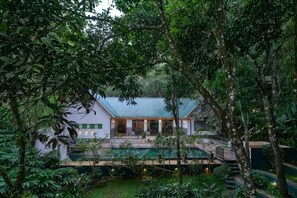 A house with a pool surrounded by lush greenery. - Reen Resorts Aanavilasam Plantation Thekkady (Thekkady)