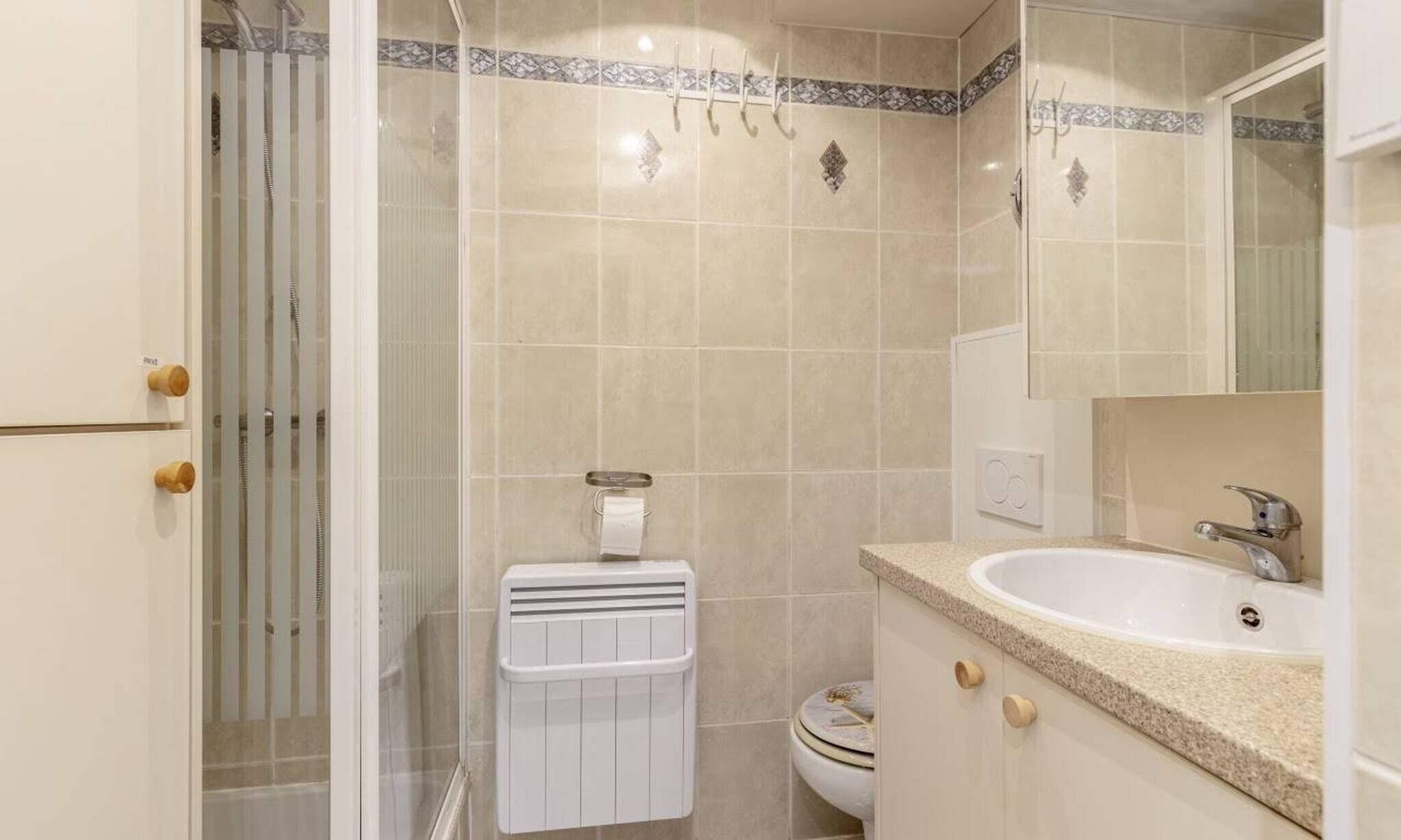 A bathroom with a shower, a toilet, and a sink.