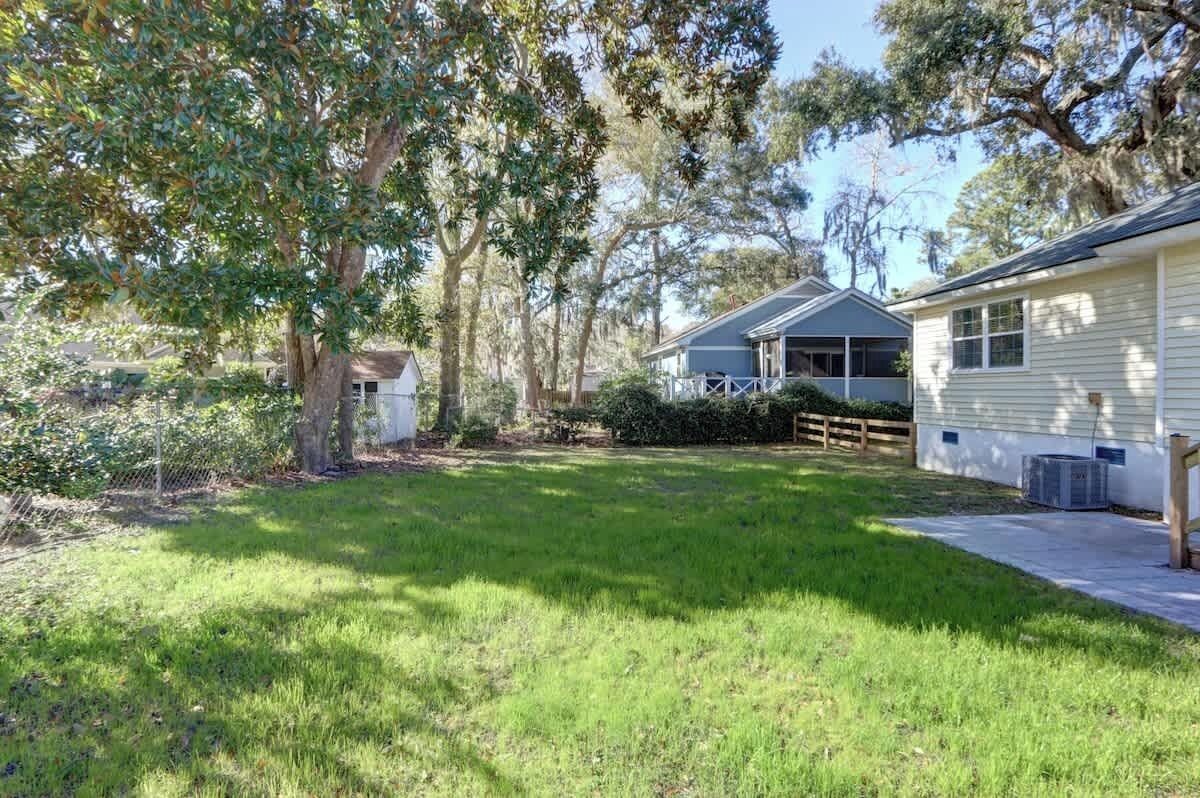 A residential property with a well-maintained lawn, a detached garage, and a house with a gabled roof.