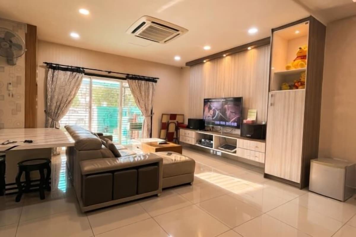 A modern living room with a sofa, TV, and entertainment unit.