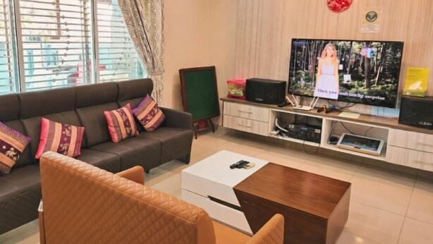 A living room with a sofa, a coffee table, a TV, and a cabinet.