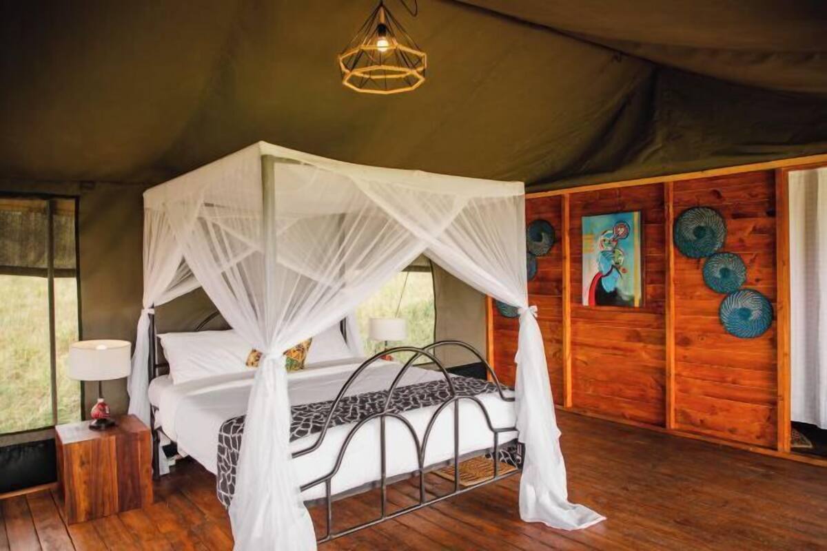 Une chambre avec un lit à baldaquin, des murs en bois et une grande fenêtre.