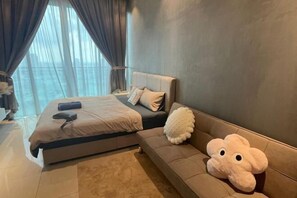 Ein Schlafzimmer mit einem Bett, einer Couch und einem großen, kuscheligen Stofftier.