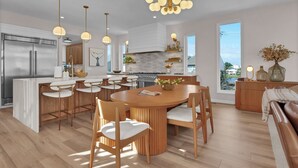 A modern kitchen with a central island, stainless steel appliances, and pendant lighting.
