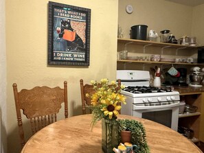 Una cocina con estufa, horno y diversos utensilios de cocina en las repisas.