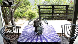 A patio with a table and chairs, surrounded by a wooden fence and trees. - Pet Friendly Breathtaking Cottage with Hot-tub in Rainbow, California (Fallbrook)