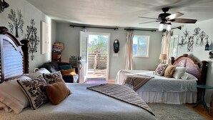 A bedroom with two beds, a ceiling fan, and a view of the outdoors. - Pet Friendly Breathtaking Cottage with Hot-tub in Rainbow, California (Fallbrook)