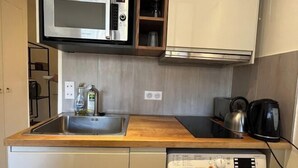 A compact kitchen with a microwave, kettle, and coffee maker. - Studio 650m to Trocadéro Tour Eiffel (Paris)