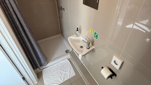 A modern bathroom with a shower, toilet, sink, and towel rack. - Studio 32-Free Private Parking (Portsmouth)